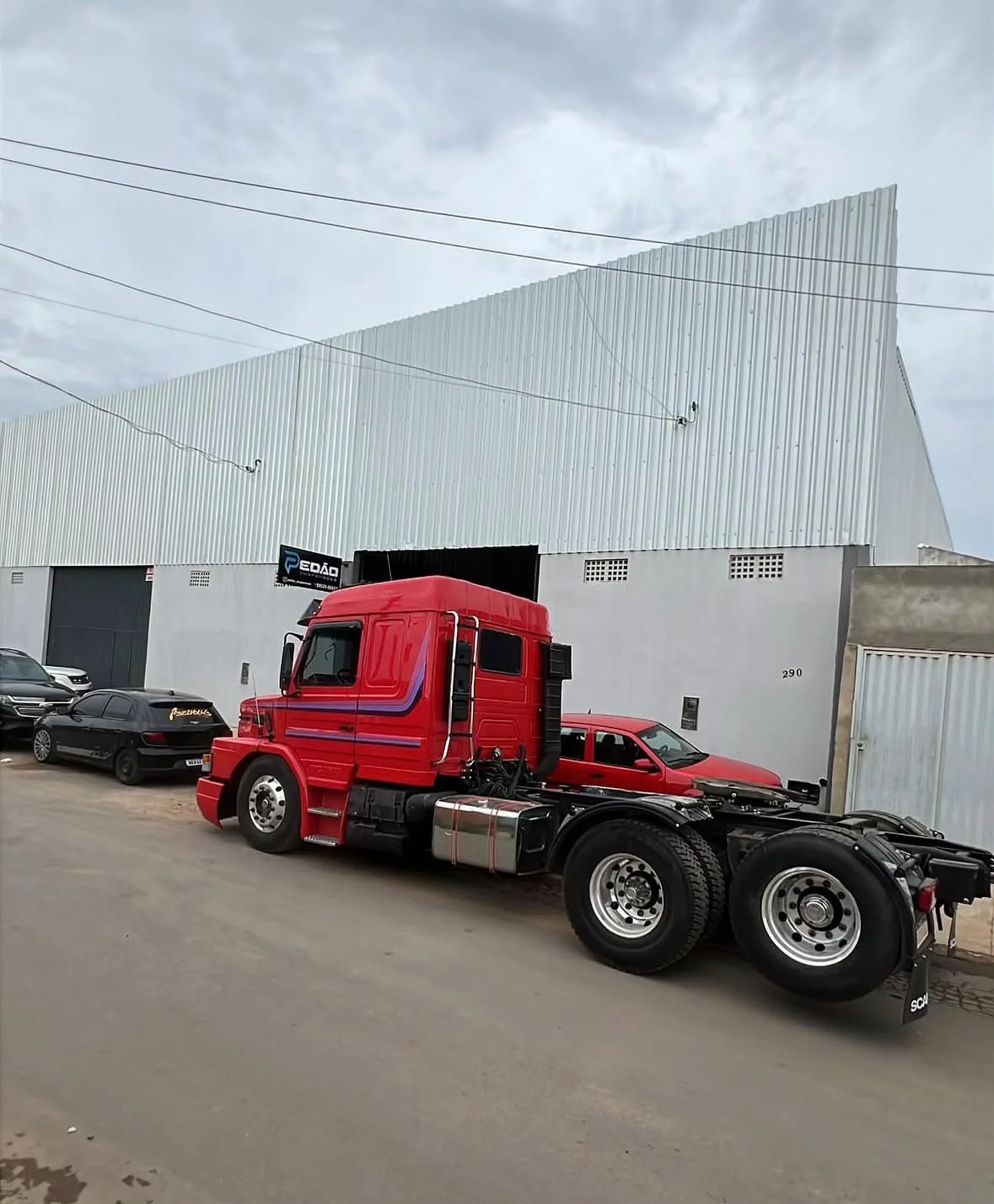 Caminhão vermelho estacionado na frente da oficina